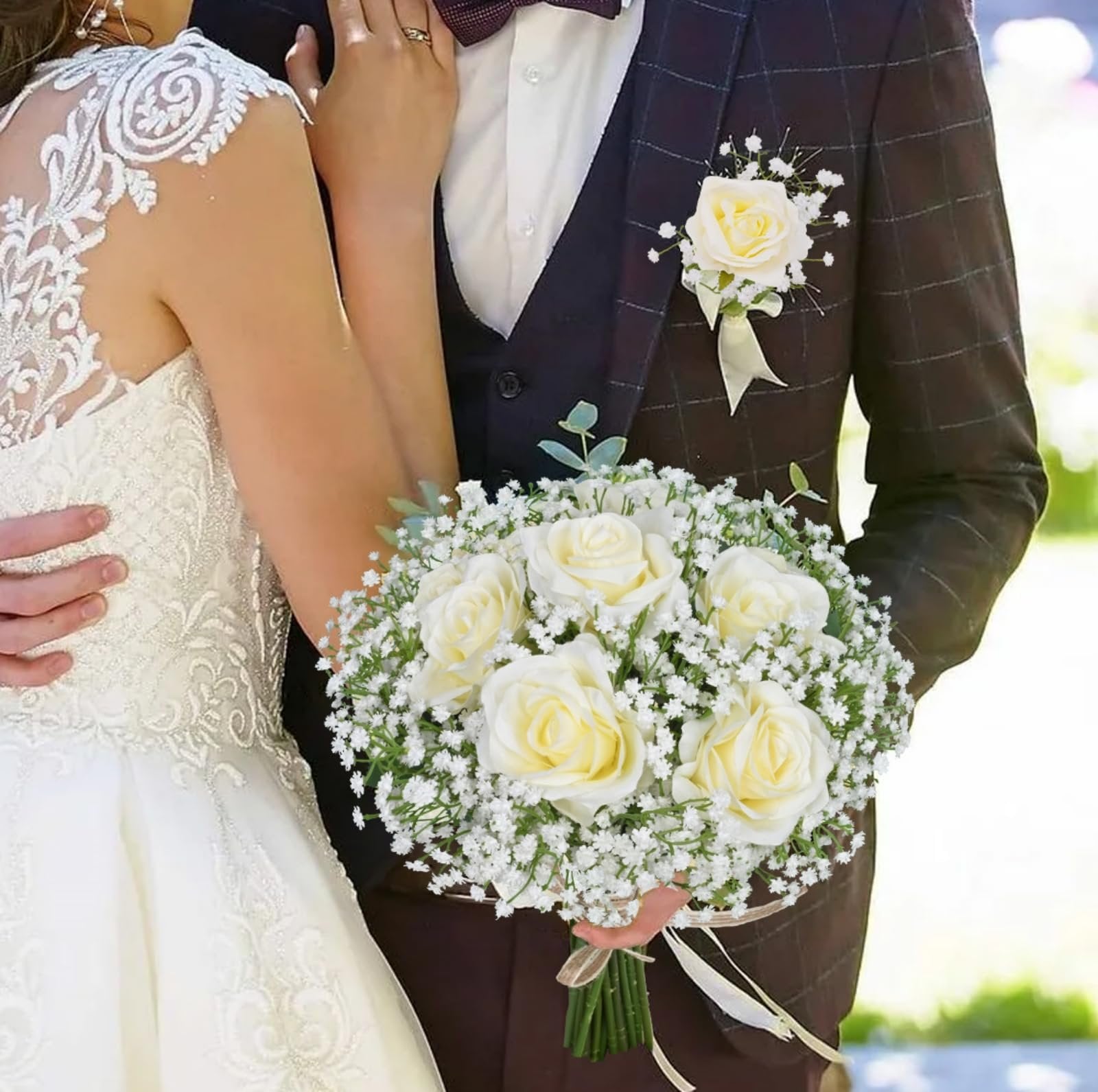 Bride and groom holding a bouquet of white roses and baby's breath flowers