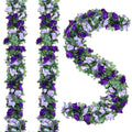 Artificial purple and lavender rose garlands with green leaves on a white background, arranged in vertical strands and a curved shape.
