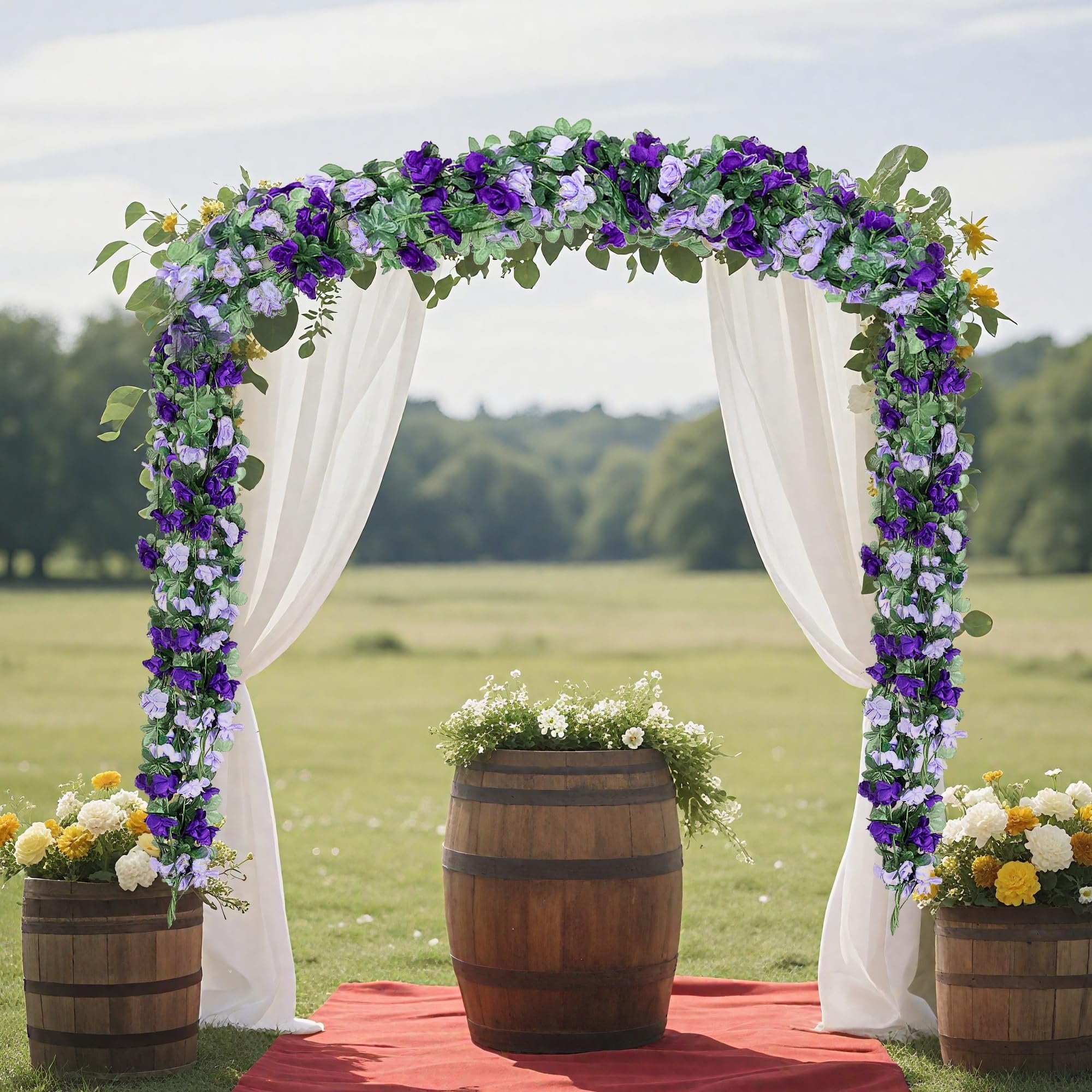 Wedding arch decorated with purple and white artificial rose garlands and greenery, with white drapes and wooden barrels of flowers.