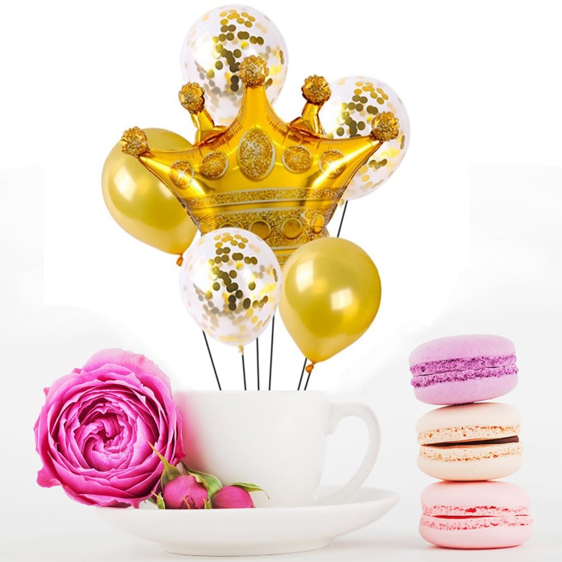 Gold crown balloon with confetti and gold balloons arranged in a white teacup with macarons and a rose
