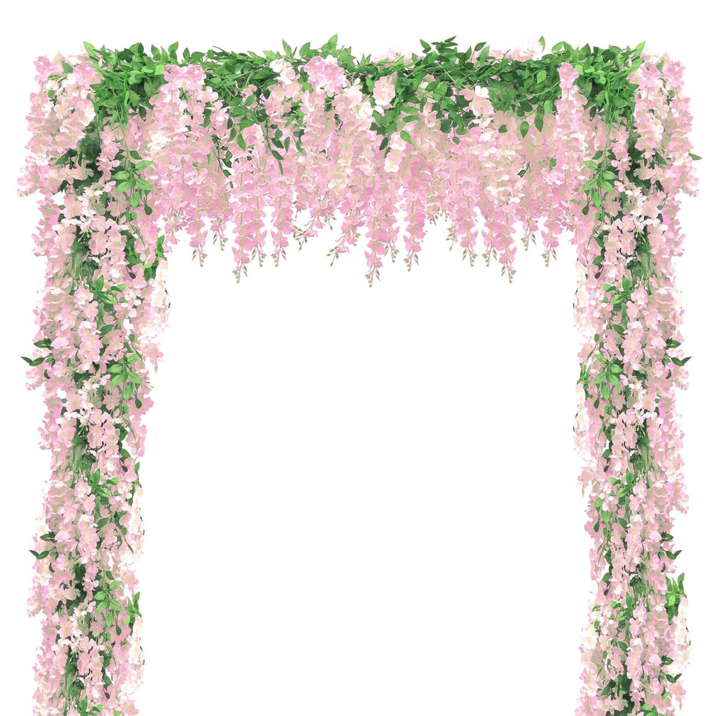Pink wisteria flower garland with green leaves draped over an archway against a white background