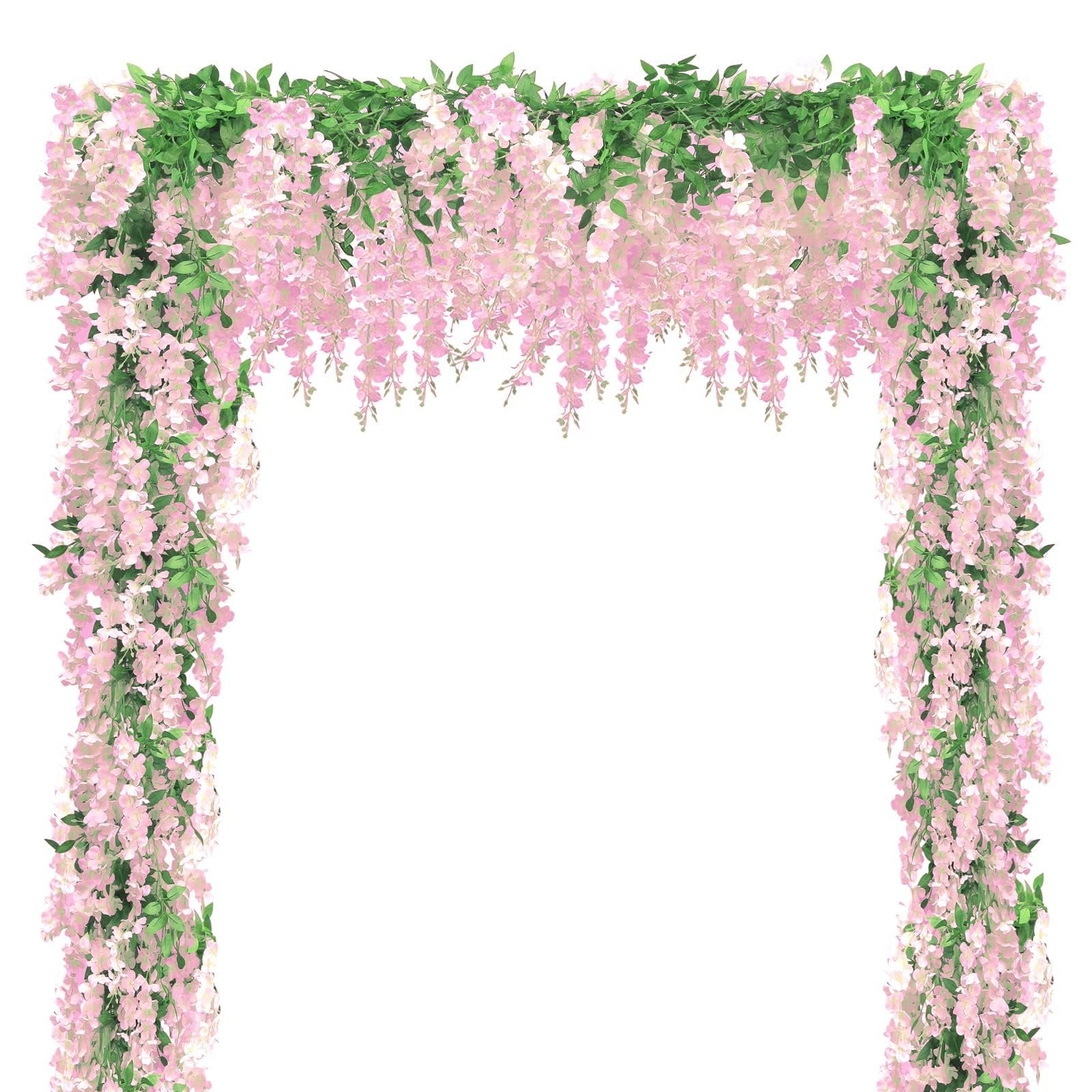 Pink wisteria flower garland with green leaves draped over an archway against a white background