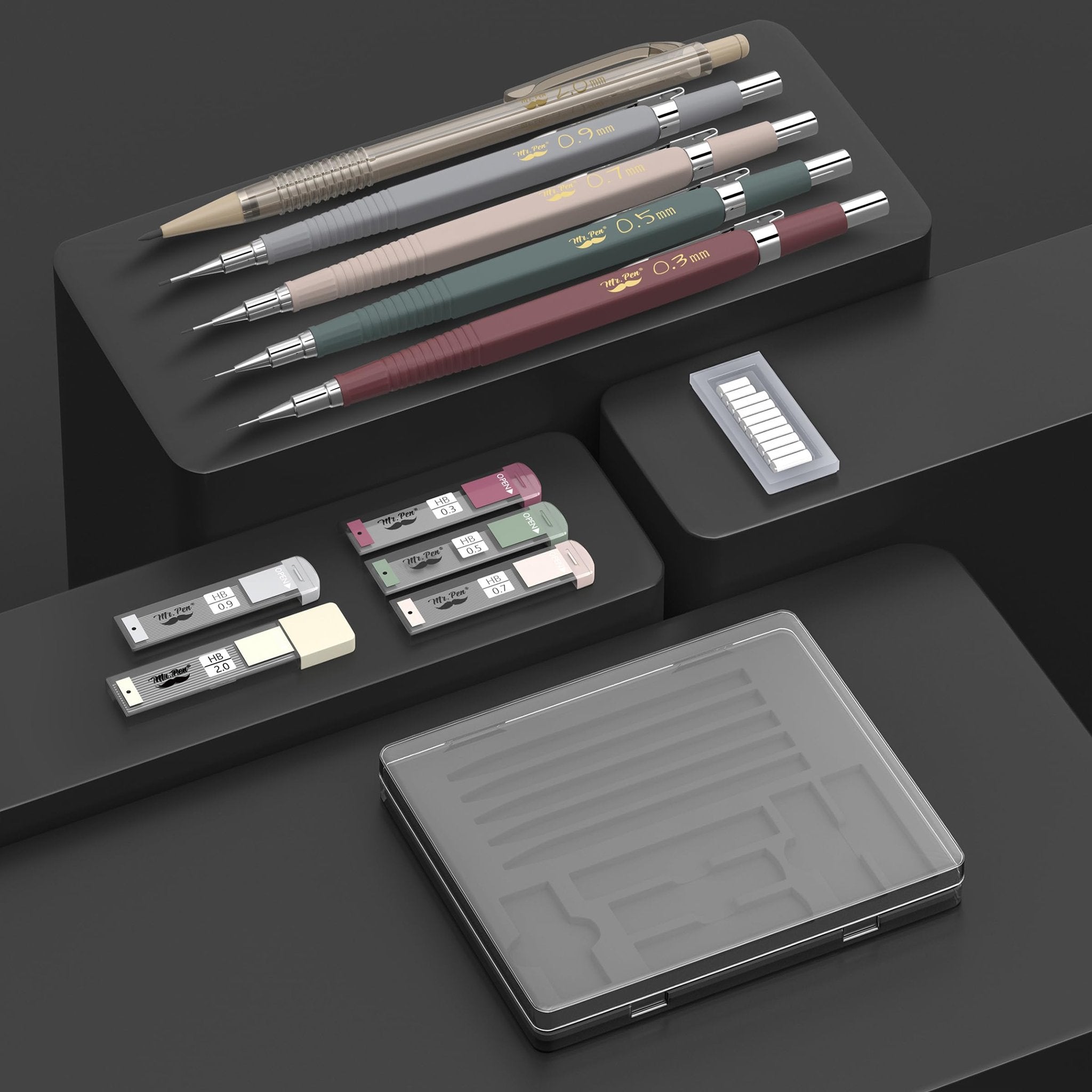 Set of five vintage mechanical pencils in various colors with different lead sizes, plus lead and eraser refills, displayed on dark platforms.