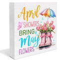 Wooden spring sign with "April Showers Bring May Flowers" text, pink tulips in rain boots, and a rainbow umbrella.