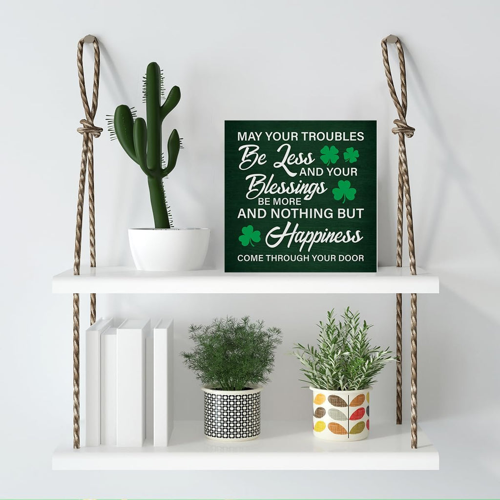 Wooden St. Patrick's Day sign with Irish blessing quote displayed on a shelf with plants and books.