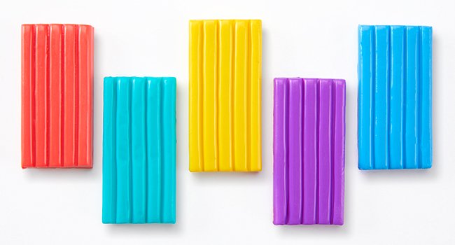 Five colorful bars of polymer clay arranged in a staggered pattern on a white background.