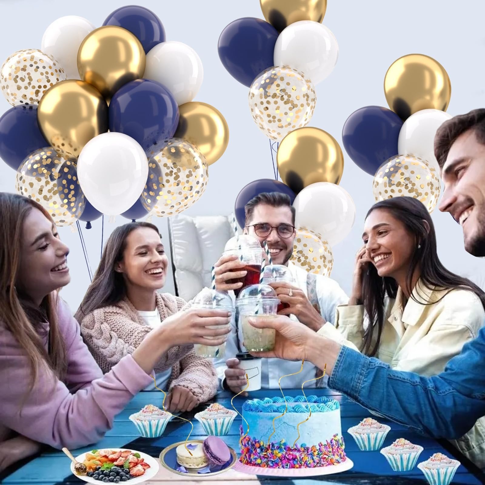 Group of friends toasting with drinks at a party with navy blue, gold, white, and confetti balloons overhead and a decorated cake on a table.