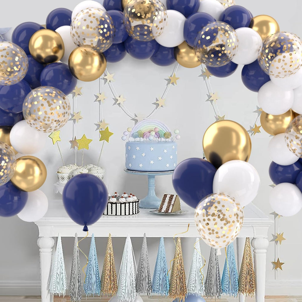 Navy blue, gold, and white balloons arranged in an arch over a table with a cake and cupcakes.