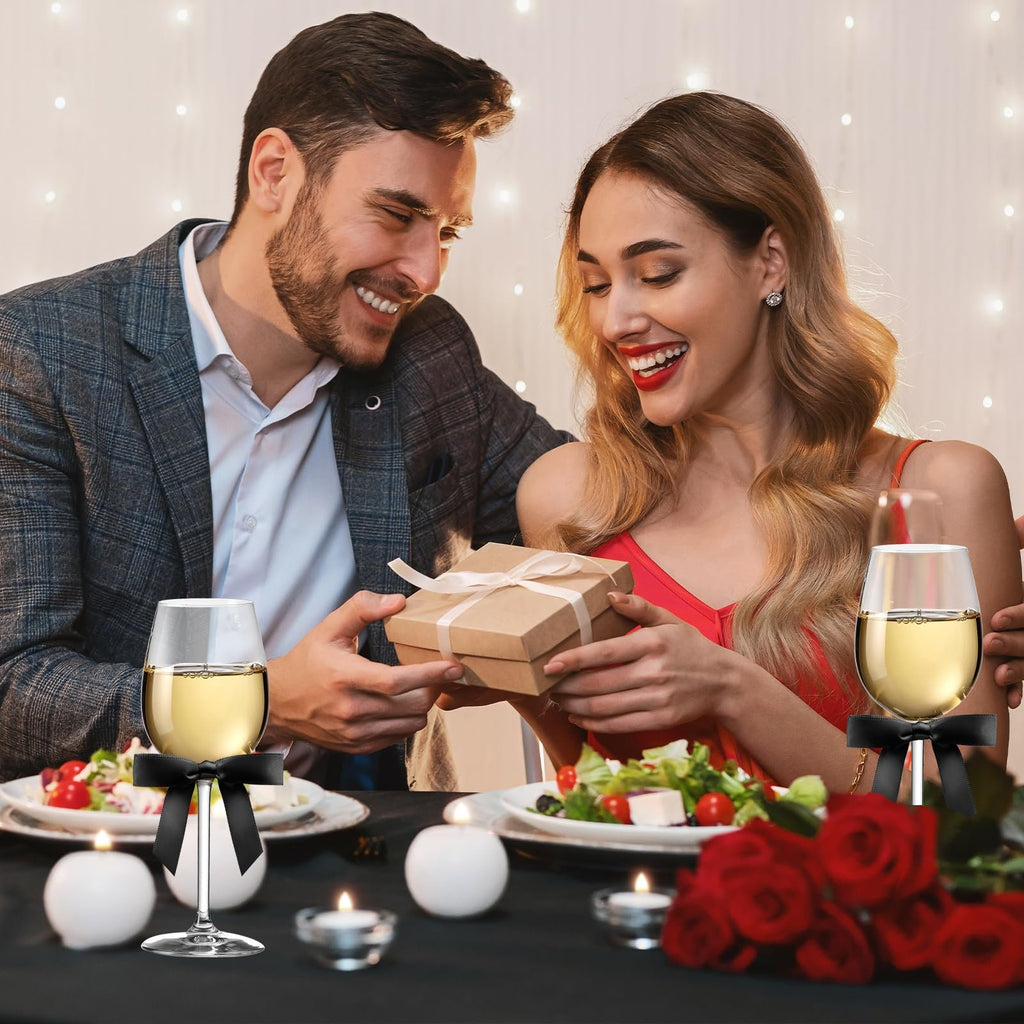 Couple celebrating at a candlelit dinner, man gifting a present to the woman.