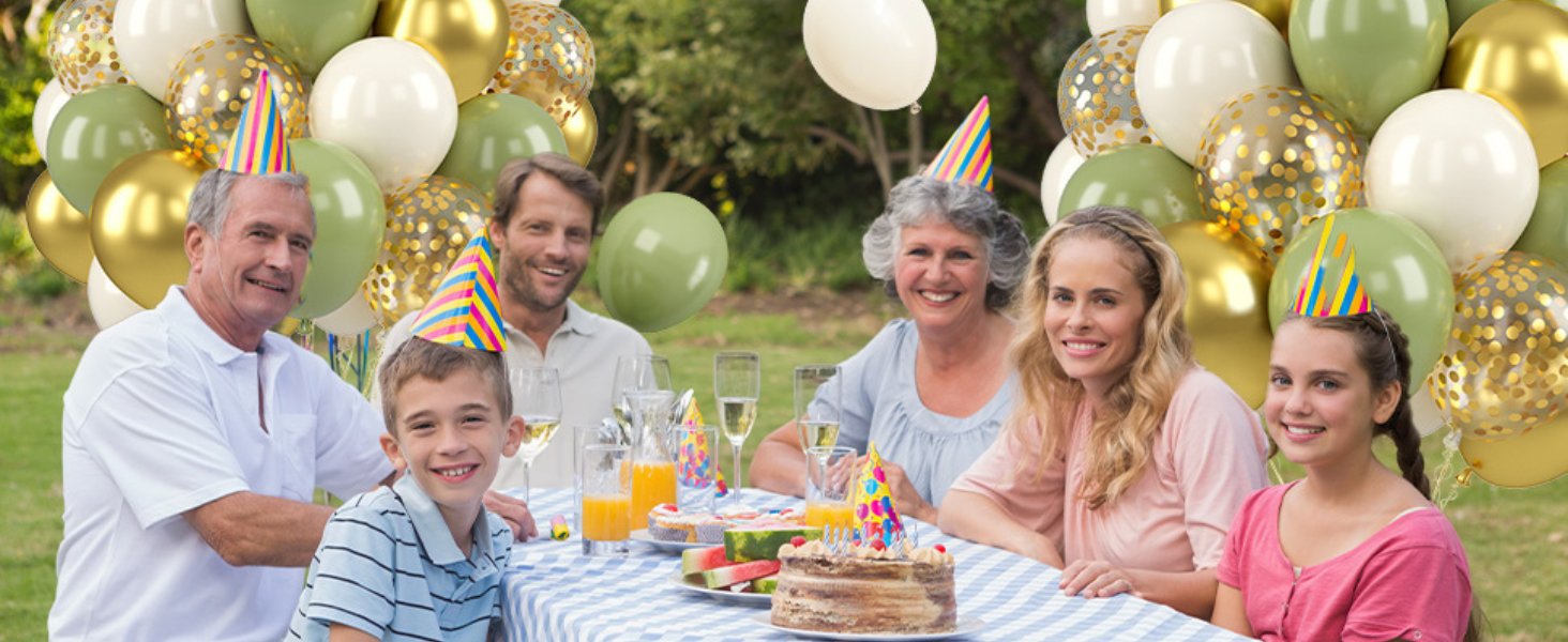 Family celebrating outdoors with sage green and gold balloons, party hats, cake, and drinks.