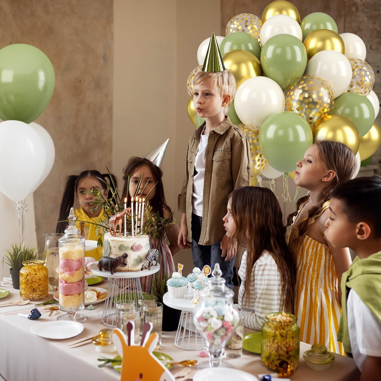 Children gathered around a table with a cake and balloons at a birthday party.