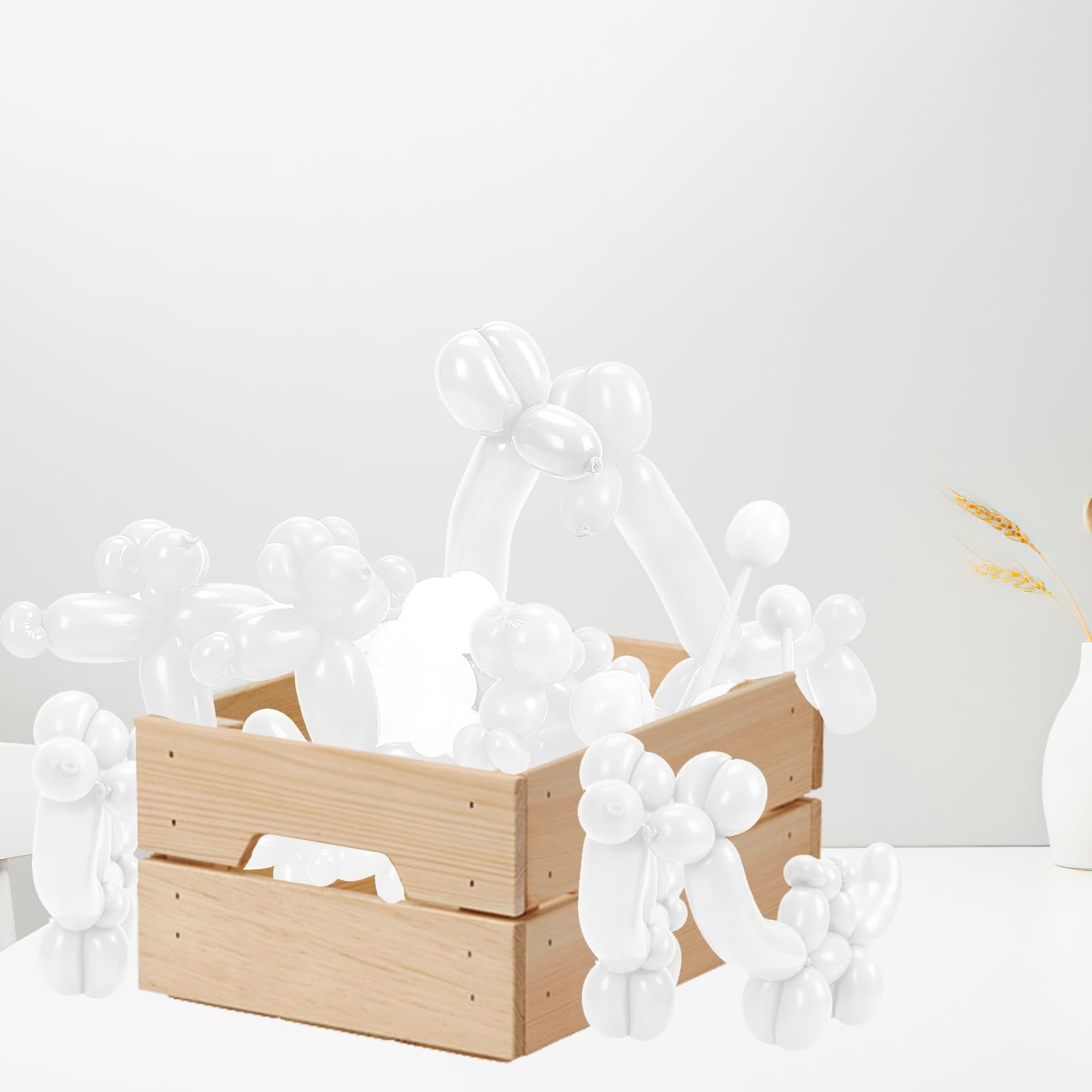 White twisting balloons shaped into animals, some in a wooden crate, others outside.