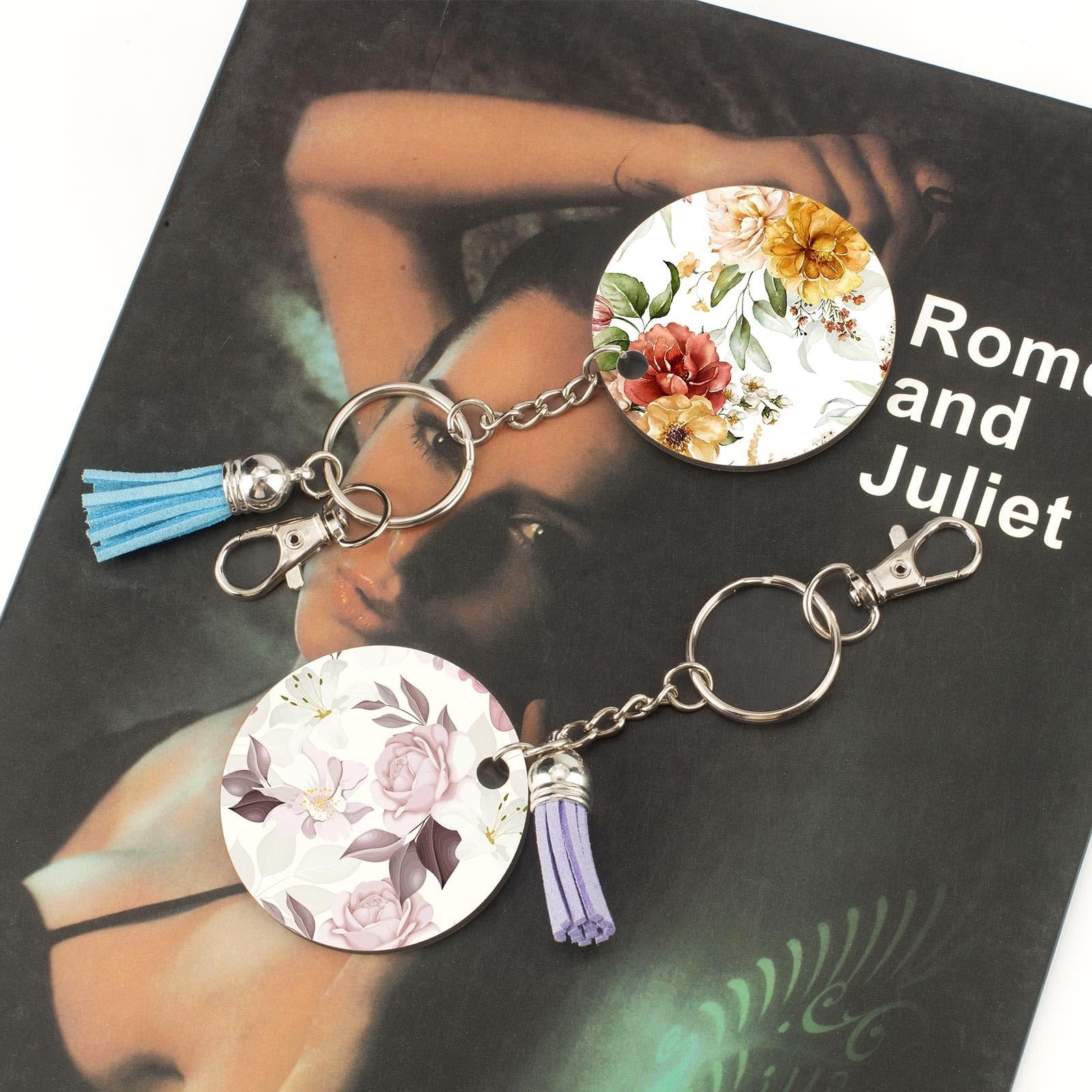 Two floral print round keychains with tassels and silver clasps on a dark background with text.