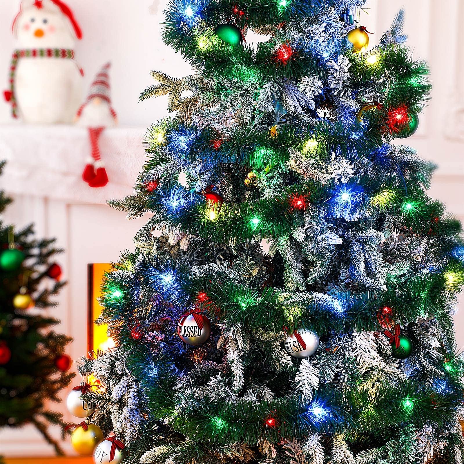Close-up of a decorated Christmas tree with colorful LED lights and ornaments, including one that says 'BLESSED'.