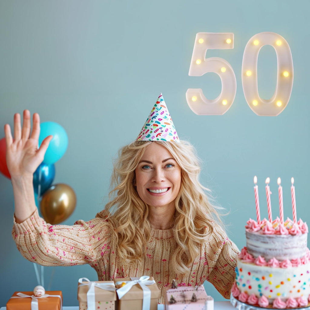 Woman celebrating 50th birthday with cake, balloons, gifts, and light-up number sign