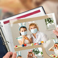 Hands holding a binder with clear plastic sheet protectors containing photos of people decorating Easter eggs.
