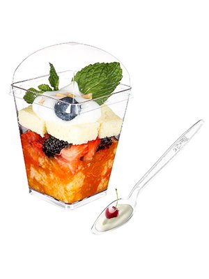 Clear plastic dessert cup filled with fruit and cake, with a lid and spoon on the side.