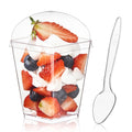 Clear plastic dessert cup filled with strawberries, blueberries, and whipped cream, with a clear plastic spoon beside it.