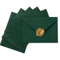 Stack of dark green A7 envelopes with gold heart-shaped wax seals on white background