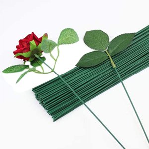 Dark green floral stem wires with artificial rose and leaves on white background
