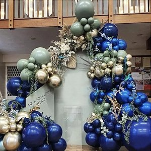 Balloon arch in royal blue, sage green, and gold with dried foliage and flowers. A light green sign reads 'MR & MRS CLARKE EST. 2022'.