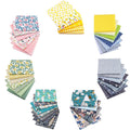 Stacks of 100% cotton fabric squares with various patterns including floral, polka dot, fruit, animal, and geometric prints.