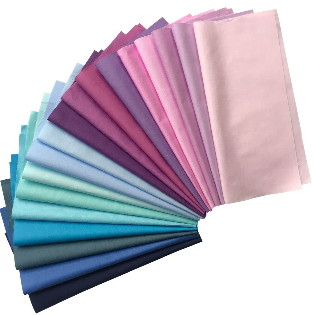 Fan of 100% cotton fabric squares in 50 solid colors, arranged in a gradient from dark blue to light pink.