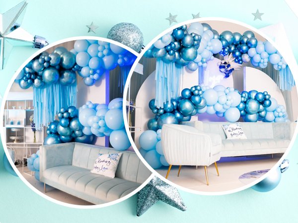 Blue and white balloon garland arch over a light blue sofa with a decorative pillow.