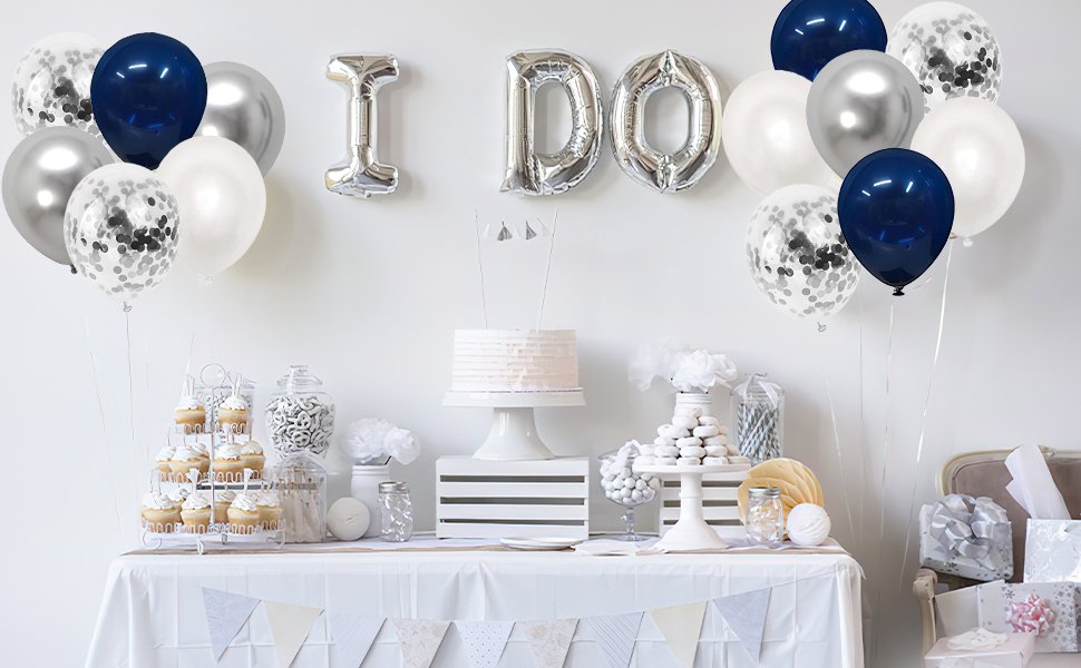 Party table with cake, cupcakes, donuts, and balloons spelling 'I DO'