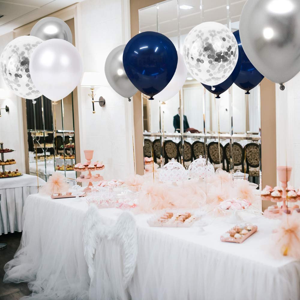 Assortment of navy blue, pearl white, silver, and confetti balloons floating above a decorated party table.