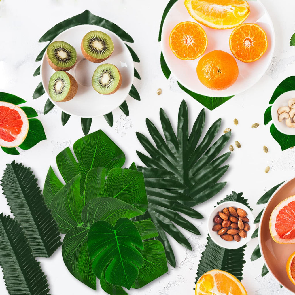 Assortment of tropical leaves with sliced fruits and nuts on a white background