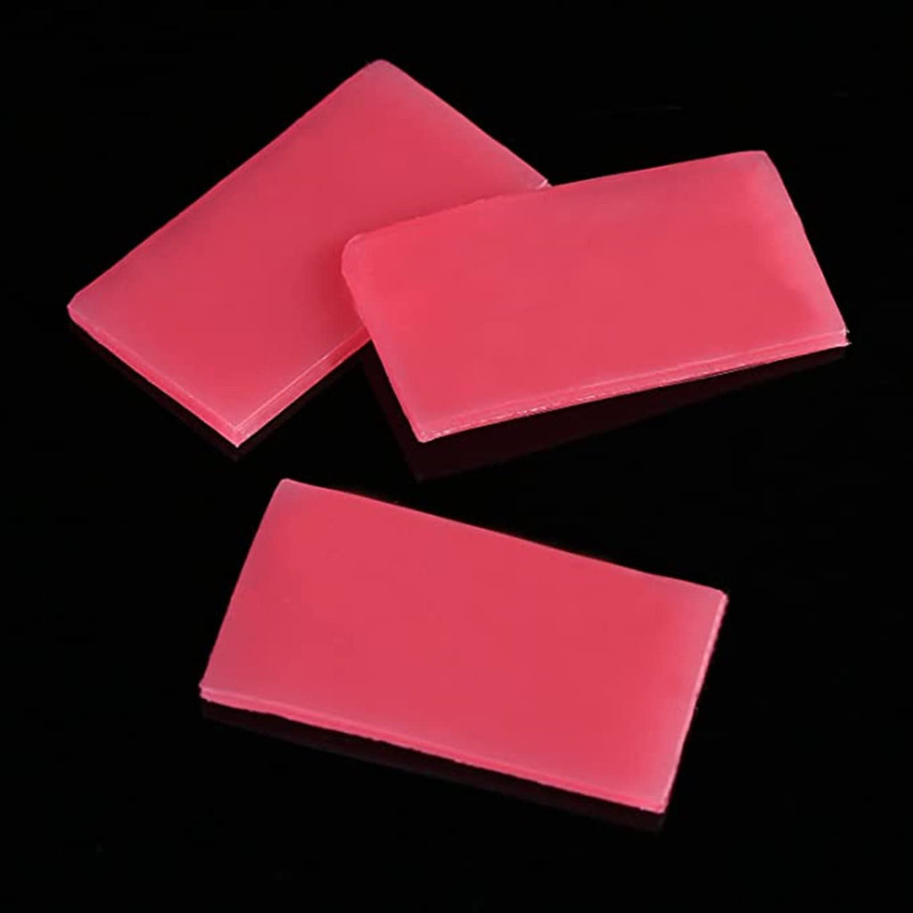 Three rectangular blocks of pink diamond painting wax clay on a black background.