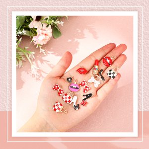 Hand holding various enamel charms including high heels, lipstick, bows, flowers, and wallets for jewelry making.