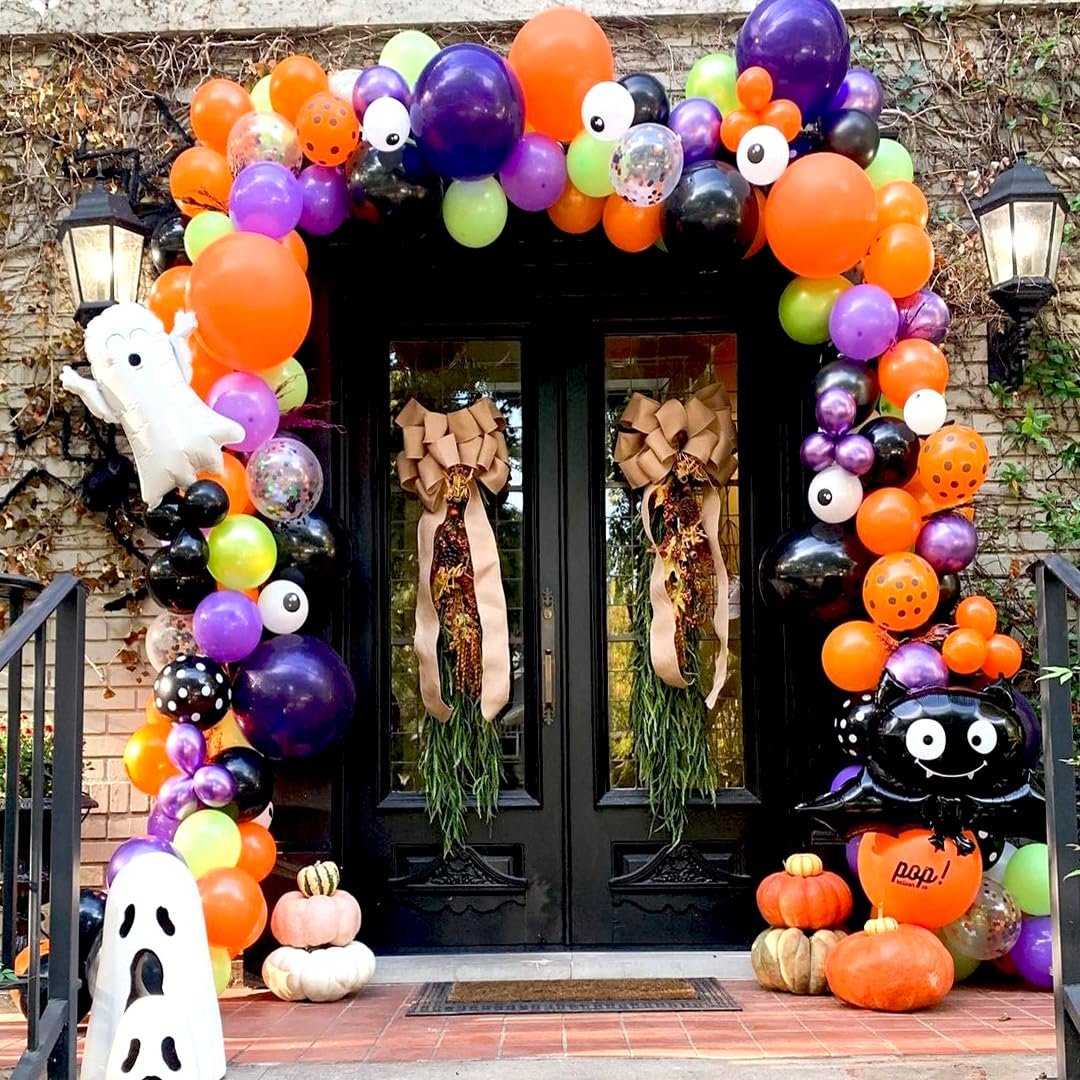 Halloween balloon arch and decorations in black, orange, purple, and green with ghost and bat balloons.