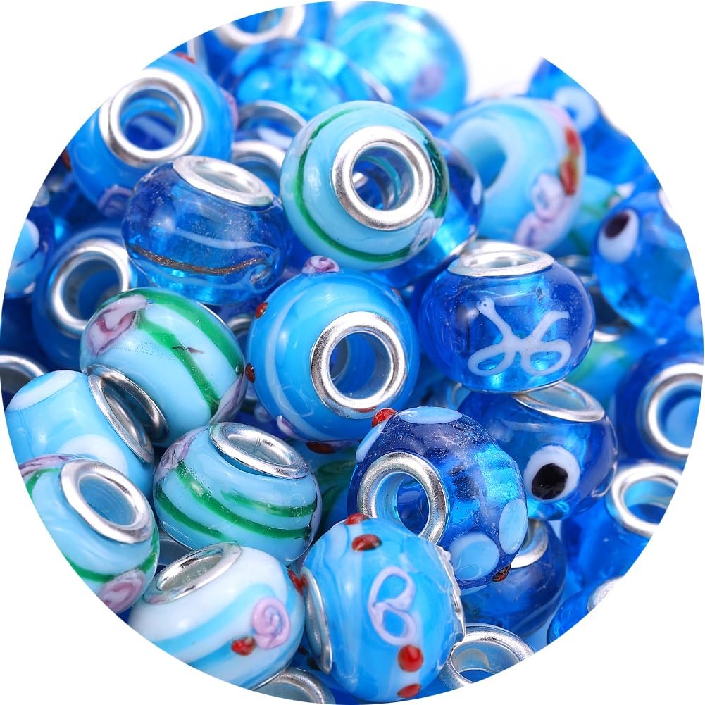 Pile of aqua blue Murano style glass beads with brass cores and decorative patterns, close-up view.