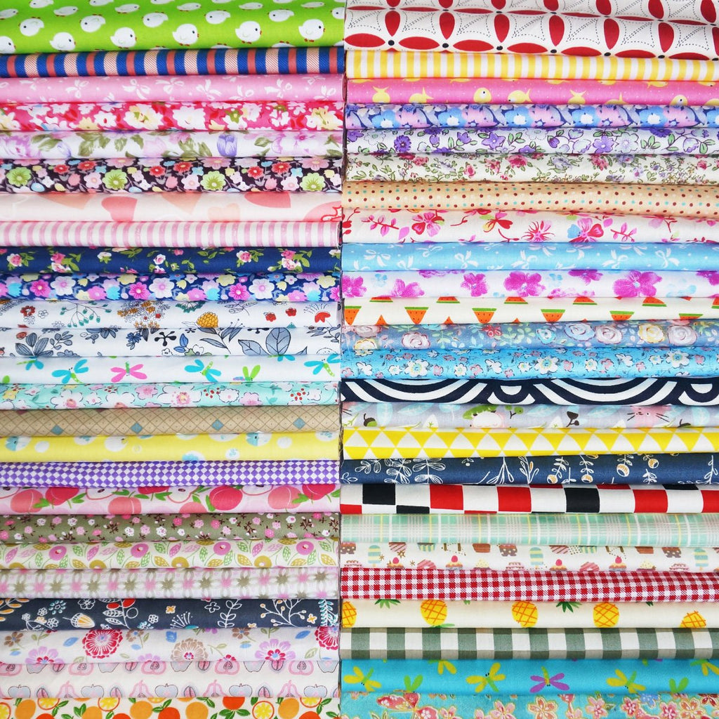 Stacks of pre-cut assorted patterned cotton fabric squares for quilting and sewing.