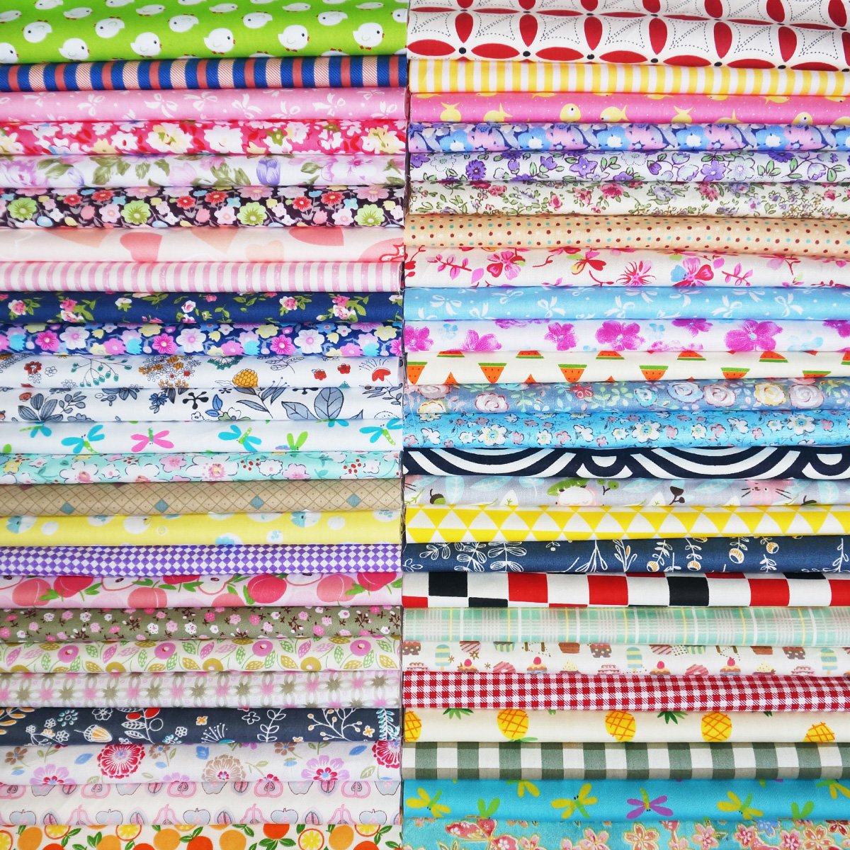 Stacks of pre-cut assorted patterned cotton fabric squares for quilting and sewing.