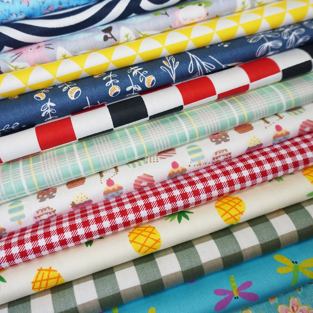Stack of assorted pre-cut cotton fabric squares with various patterns including gingham, floral, and fruit prints.