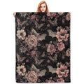 Woman holding a gothic bat and floral patterned flannel throw blanket, black with pink and grey details