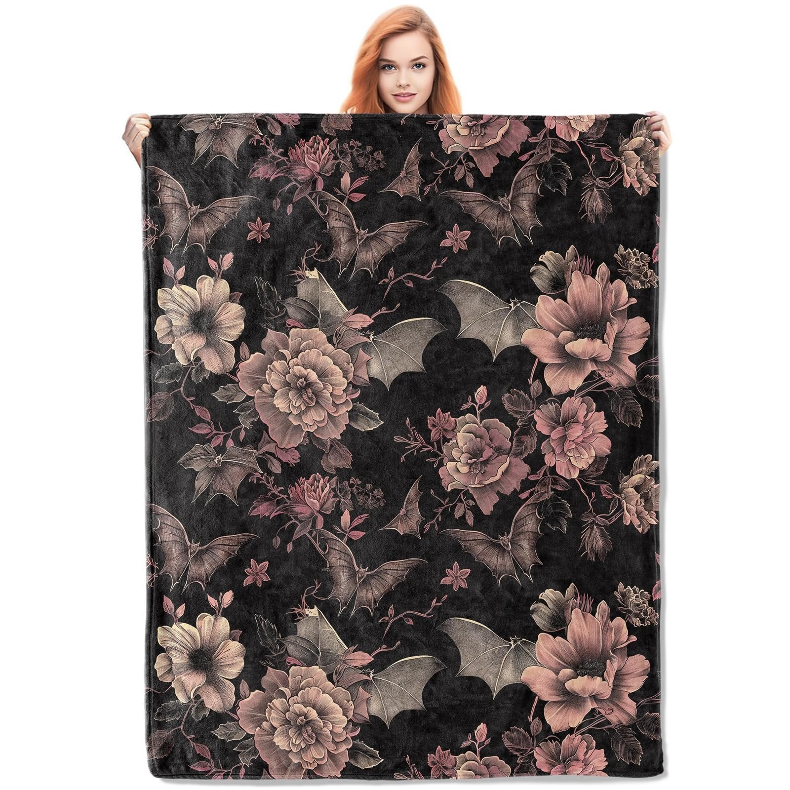 Woman holding a gothic bat and floral patterned flannel throw blanket, black with pink and grey details