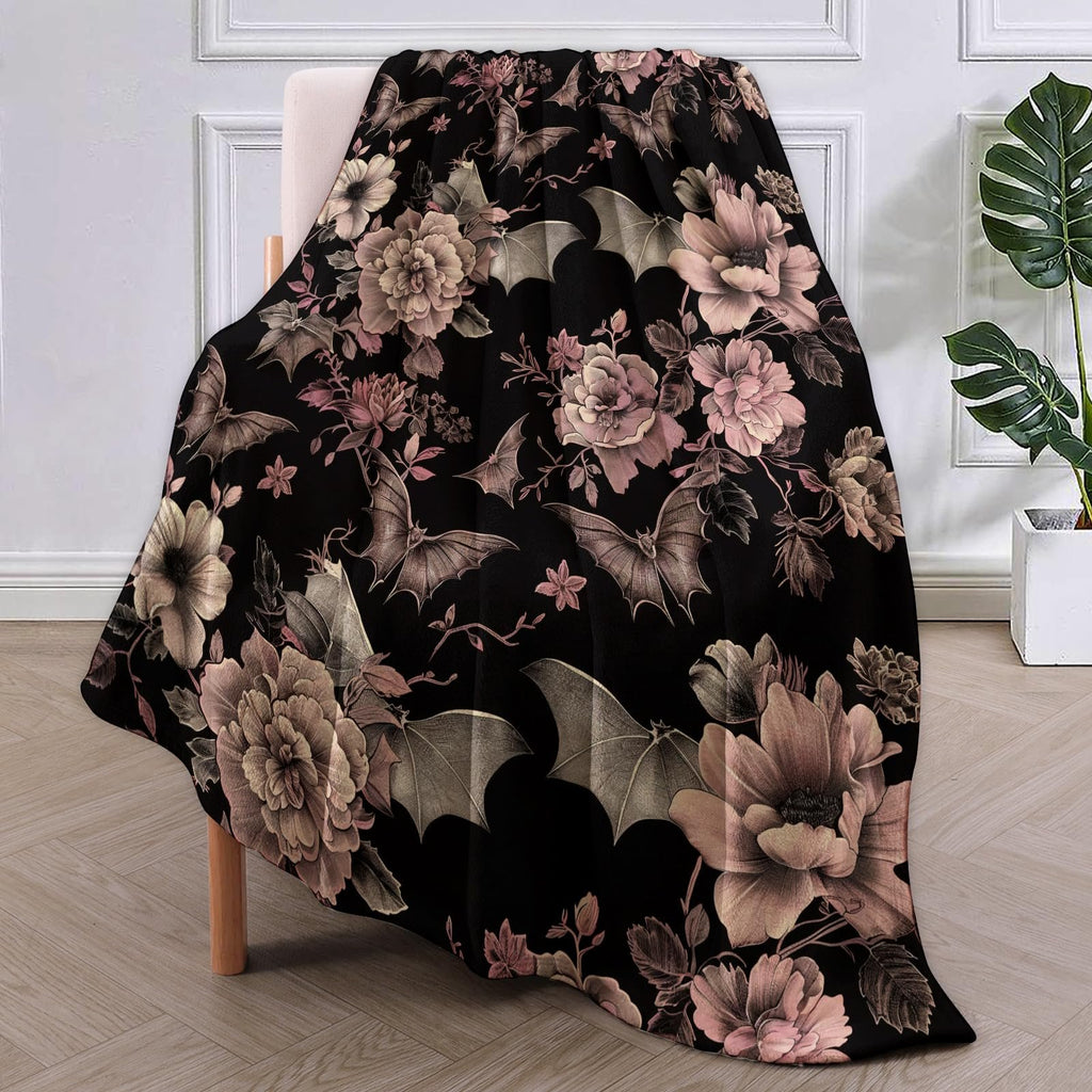 Gothic bat and floral pattern flannel throw blanket draped over a chair.