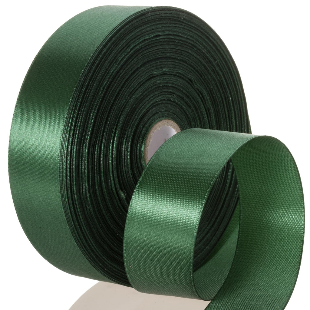 Roll of forest green satin ribbon with a section unspooled, showing the smooth satin side and the textured back.