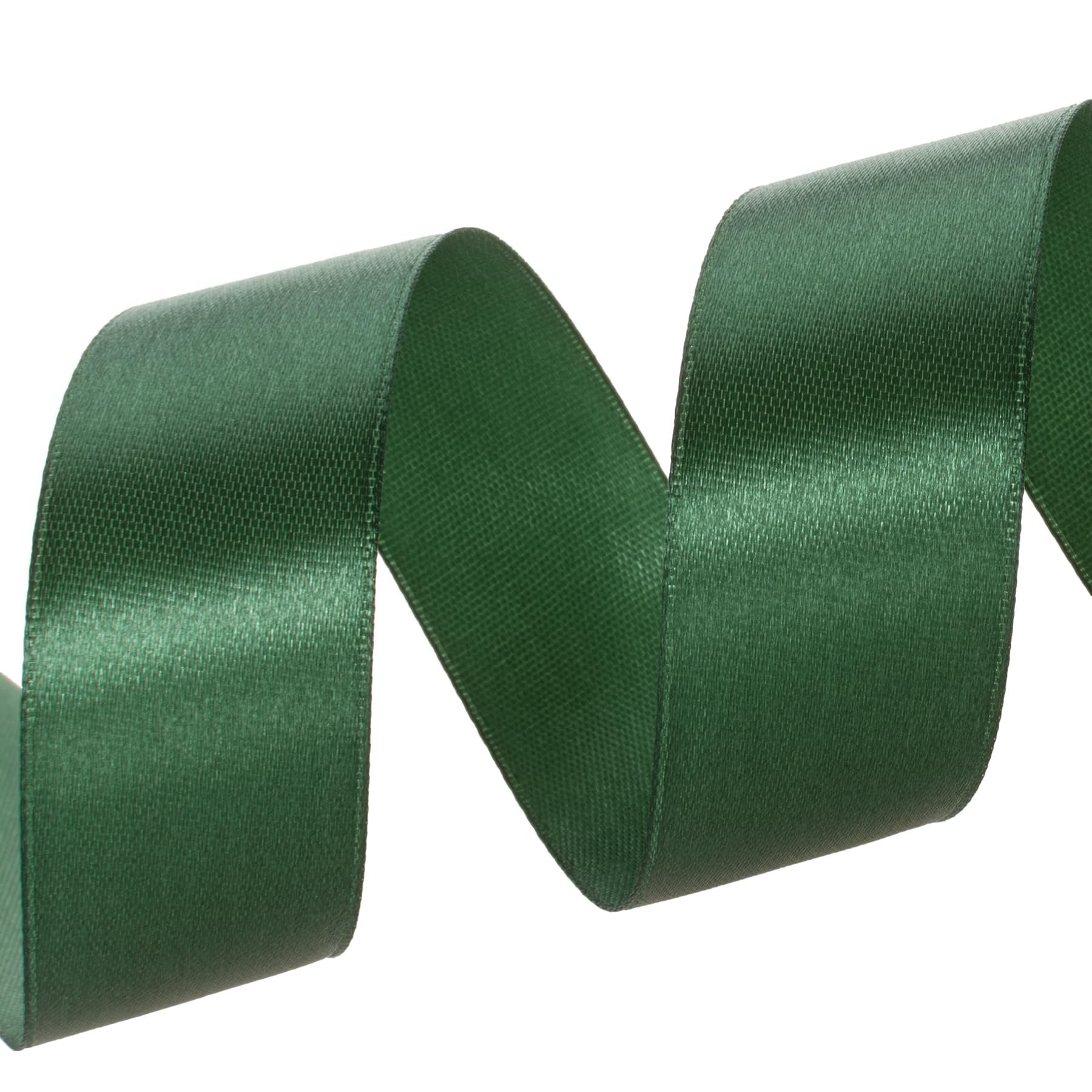 Forest green satin ribbon curled on a white background, showing texture and sheen.