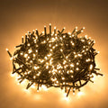 Cluster of warm white LED string lights coiled together, illuminated against a warm background.