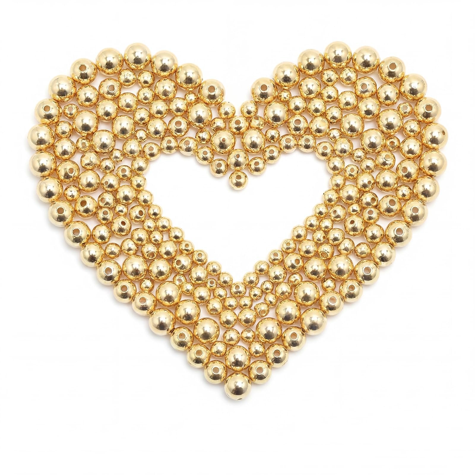 Heart shape formed by assorted gold-filled brass round spacer beads on a white background