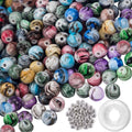 Pile of 8mm acrylic craft beads with ink patterns in various colors, plus spacer beads and crystal string.