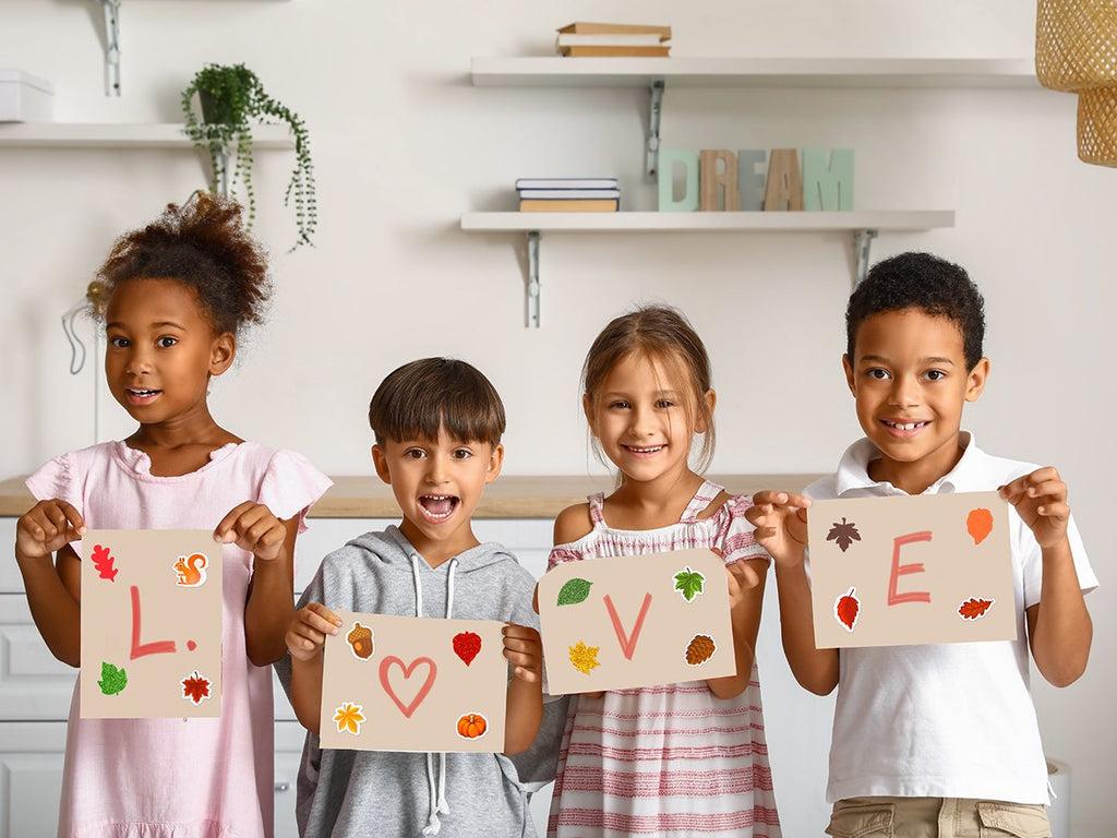 Four children hold up signs with fall-themed stickers and letters spelling 'LOVE'.