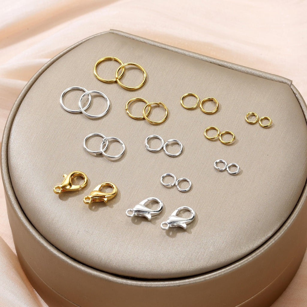 Assortment of gold and silver jump rings and lobster clasps arranged on a display stand.