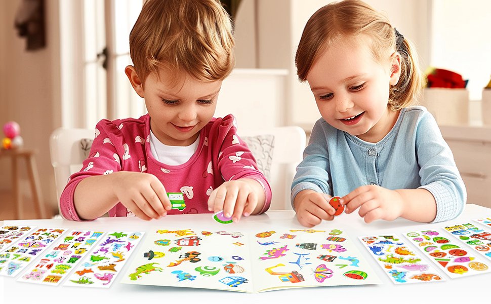 Two young children happily placing puffy stickers from sheets into a sticker book on a table.