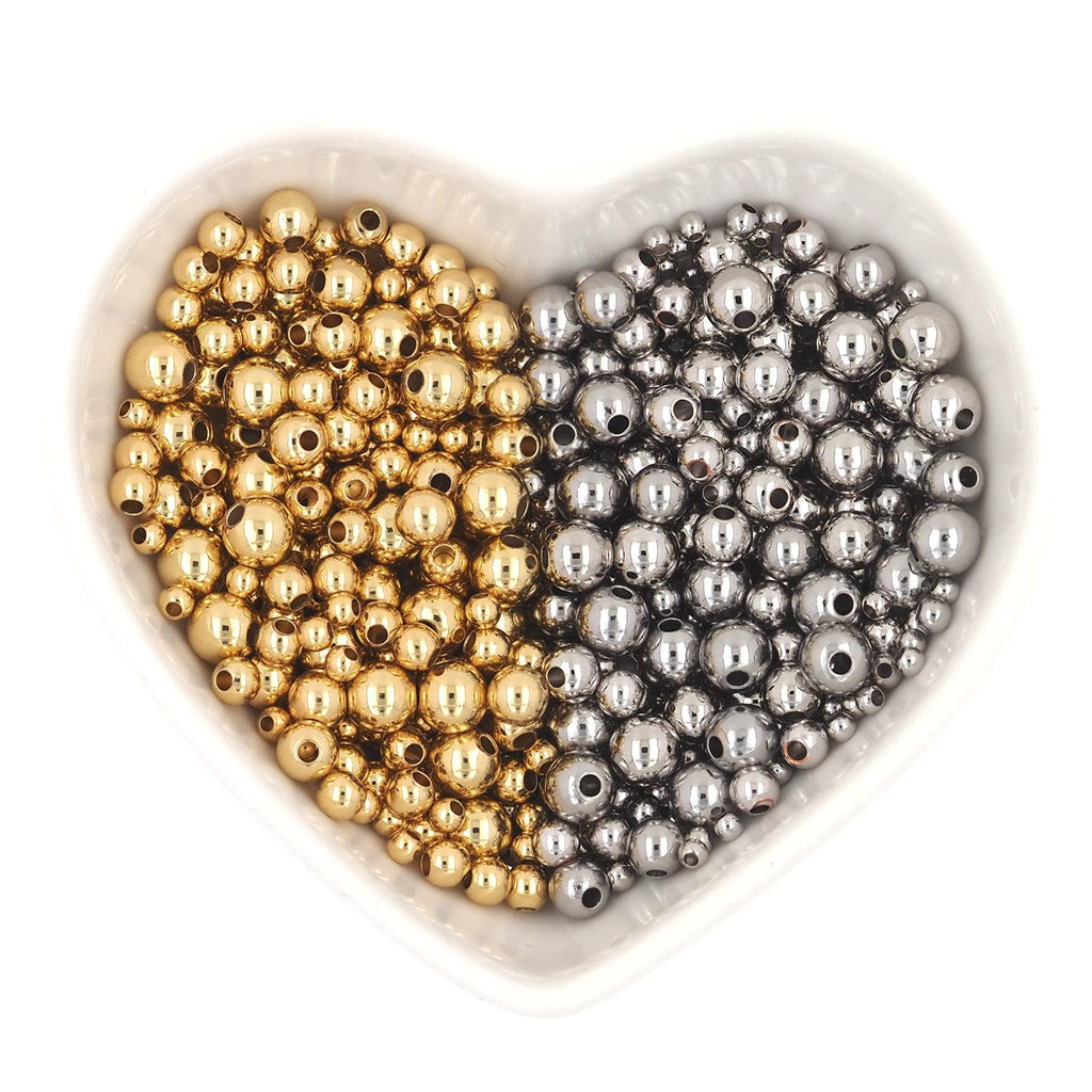 Heart-shaped dish filled with gold and silver round spacer beads for jewelry making